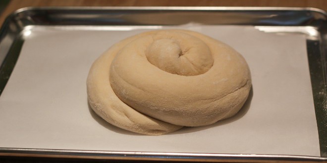 Punch down the dough and roll it into a long thick rope. Coil that around itself and place it on a baking sheet lined with parchment paper.
