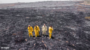 Firefighters on scorched land in southern Israel.