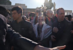 Yizhar Hess (center) tries to make his way through a crowd at the Western Wall. (Photo by Lev Gringauz)