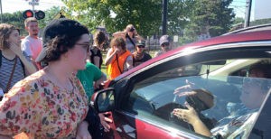 Jordan Breslau tries to explain to a woman trying to drive away about the purpose of the protest.