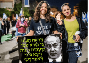 Roni Peretz and a friend attend their 14th Saturday night protest in Jerusalem. (Photo by <a href="https://www.ethanrobertsphotos.com/" target="_blank" rel="noopener">Ethan Roberts Photography</a>)