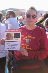 Rachel Amberger holds a kidnapped poster of her "kibbutz father" Shlomo Mansour, who was taken from Kibbutz Kisufim (Photo by Lev Gringauz/TC Jewfolk).