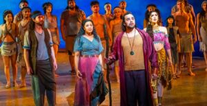 Moses (Luke Brady, center) flanked by Miriam (Alexia Khadime) to his left and Tzipporah (Christine Allado) to his right, with Hebrew slaves in the background in The Prince of Egypt: The Musical. (Photo from Riverside Theatres website.)