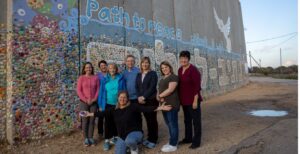 Minnesota legislators at the Path To Peace Wall in Nativ HaAsara with the artist, Tsameret, kneeling in front. (Photo courtesy Ethan Roberts/JCRC).