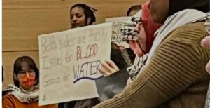 A sign that reads "Both sides are thirsty/Israel for blood/Gaza for water” was held up at the Jan. 8 Minneapolis City Council meeting.