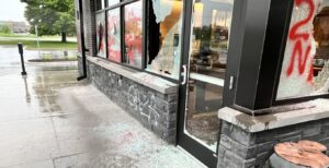 The shattered windows and doors, and Pro-Hamas graffiti on a Starbucks in Woodbury. (Facebook).