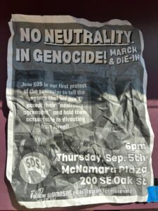 A crumpled up flier for an event titled "No Neutrality In Genocide". (Photo by Elise Long)