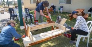 Jewish National Fund-USA volunteers help repair outdoor furniture in the Israeli community of Dekel, located 4 miles from the borders of Egypt and Gaza. (courtesy)
