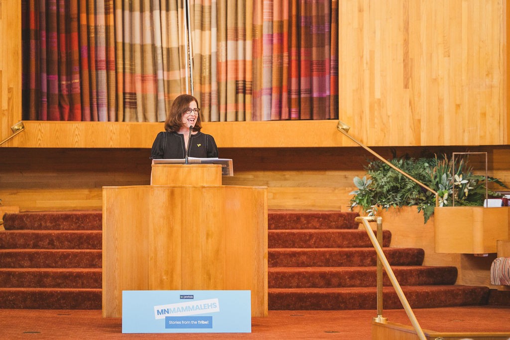 Ann Miller, a 2025 Stories from the Tribe Twin Cities storyteller on the bima!(Sydnee Bickett Photography)