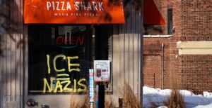 Graffiti in the window of a now closed Pizza Shark pizza shop on Hennepin Avenue in Minneapolis on January 19, 2026. Photo by Chad Davis/Wikimedia Commons)