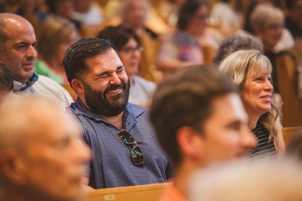 An audience member laughing at a story.
