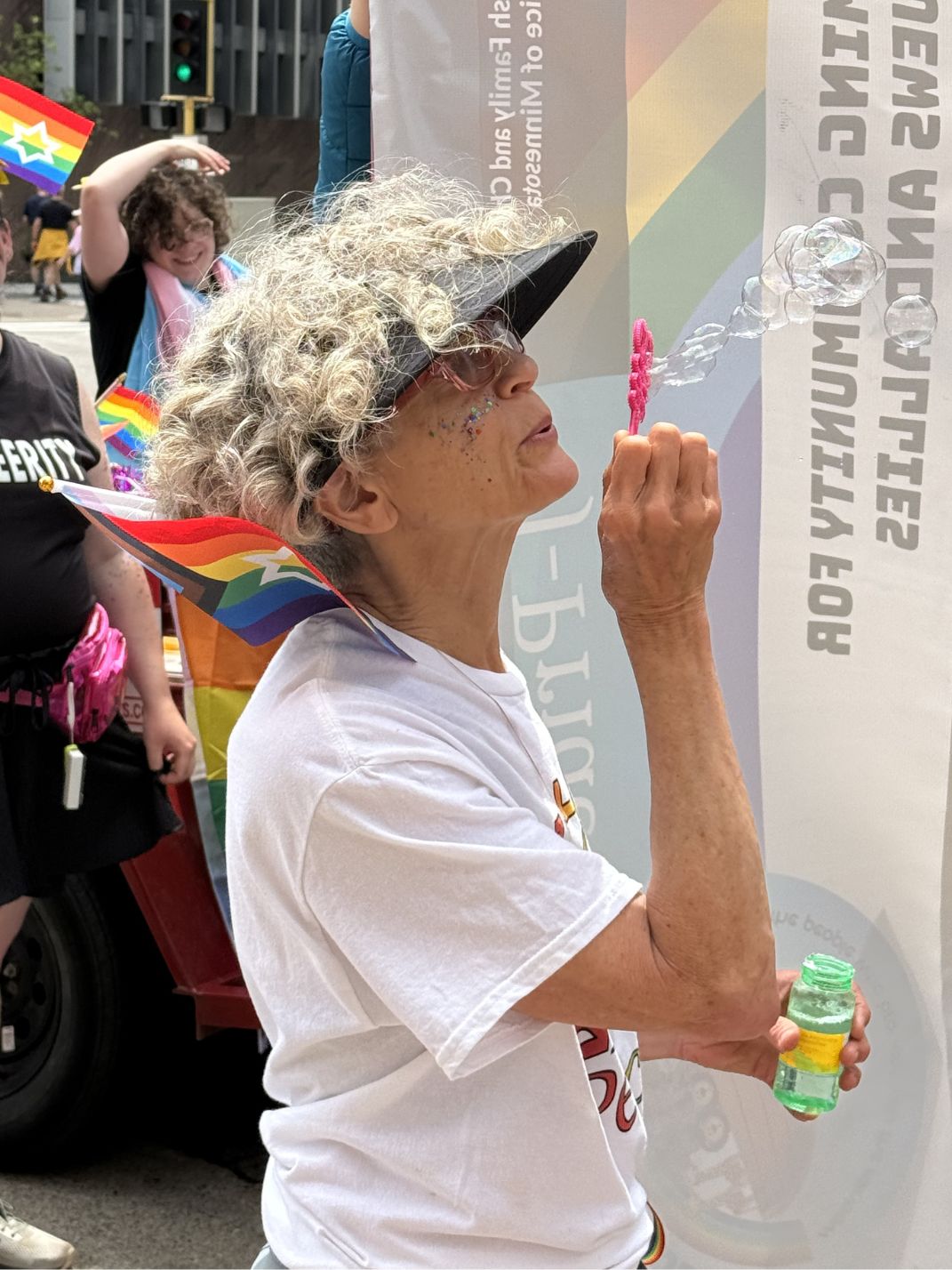 Belle blows bubbles before the start of the 2026 Pride Parade.