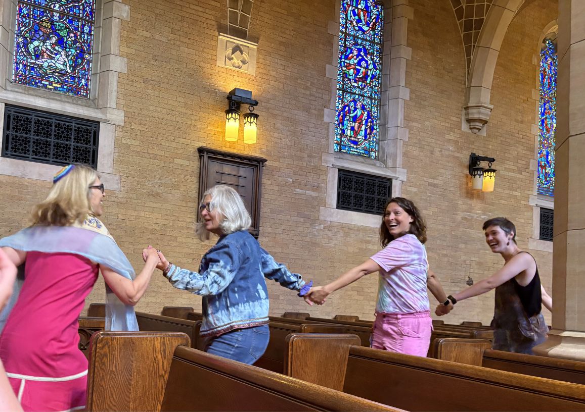 Cantor Tamar Havilio (left) leads people dancing through the aisles at the J-Pride Shabbat service. (photo courtesy JFCS)