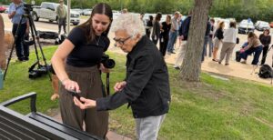 JCRC staffer Julia Fromstein shows Rivel Greenberg how to scan the QR code on the Kindertransport Memorial Bench. (Lonny Goldsmith/TC Jewfolk).